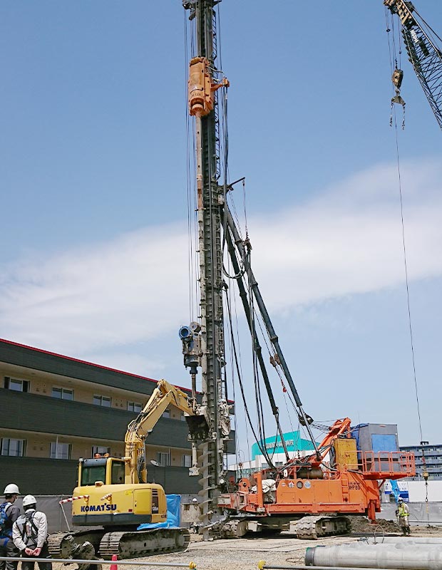 杭打機とショベルによる基礎工事の現場